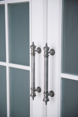 Closed white door with beautiful silver handles.