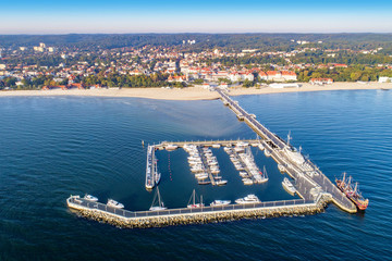 Sopot-resort in Polen. Houten pier (molo) met jachthaven, jachten, toeristisch piratenschip, strand, vakantie-infrastructuur, hotels, park en promenade. Luchtfoto bij zonsopgang.