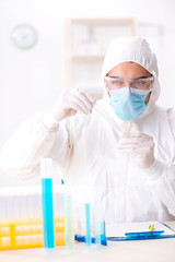 Young chemist student working in lab on chemicals