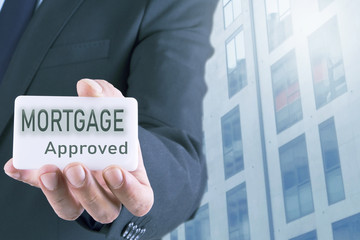 businessman with a card about mortgages. mortgage and business concept