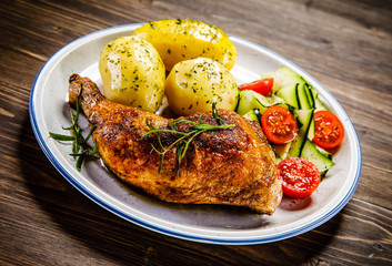 Barbecued chicken legs with boiled potatoes and vegetables