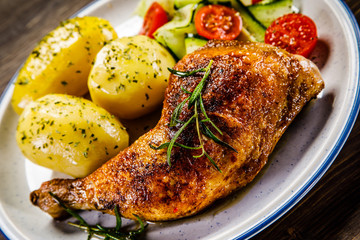Barbecued chicken legs with boiled potatoes and vegetables
