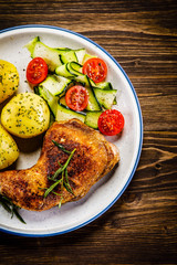 Barbecued chicken legs with boiled potatoes and vegetables