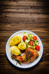 Barbecued chicken legs with boiled potatoes and vegetables