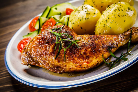 Barbecued chicken legs with boiled potatoes and vegetables