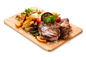 Roast steak with vegetables on cutting board