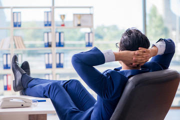 Young handsome businessman employee working in office at desk