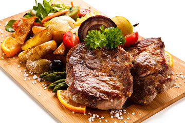 Roast steak with vegetables on cutting board