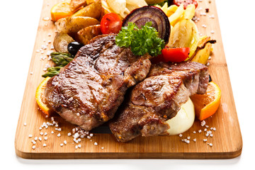 Roast steak with vegetables on cutting board