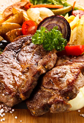 Roast steak with vegetables on cutting board