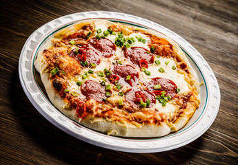 Pizza salami on wooden background