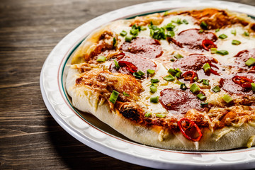 Pizza salami on wooden background