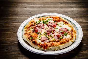 Pizza salami on wooden background