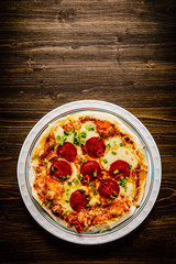 Pizza salami on wooden background