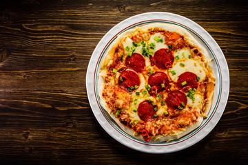 Pizza salami on wooden background