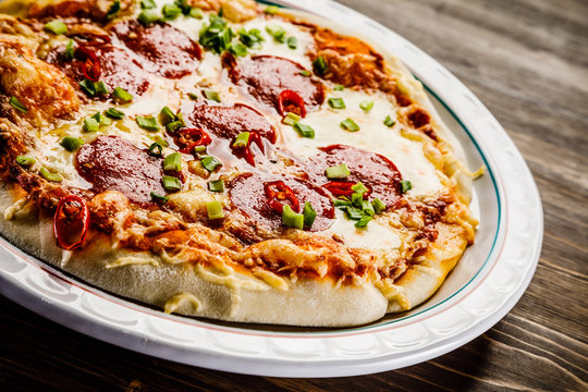 Pizza salami on wooden background