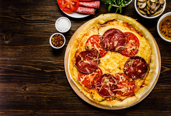 Pizza with salami, mushrooms and vegetables