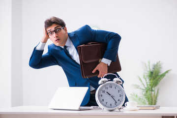 Businessman employee in urgency and deadline concept with alarm 