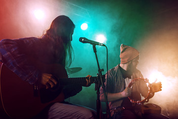 The musician plays an acoustic guitar.