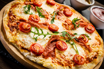 Pizza with ham and vegetables on wooden table