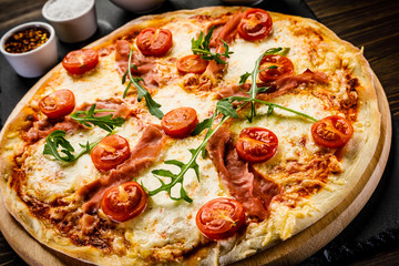 Pizza with ham and vegetables on wooden table