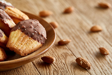 Freshly baked almond cookies piled on ceramic plate over rustic background, top view, close-up, selective focus
