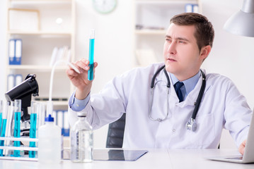 Fototapeta premium Male doctor looking at lab results in hospital