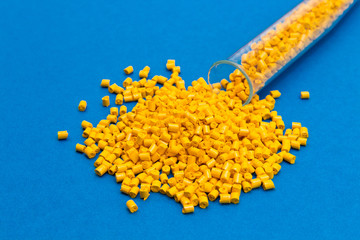 Plastic raw materials in granules for industry.Yellow Polymer on a blue background. Plastic granules after processing of waste polyethylene and polypropylene.Polymer. BPA FREE.Plastic pellets .