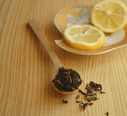 Spoon of dry green tea with fruits