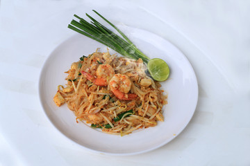 Thai style noodles, Pad Thai, stir-fried rice noodles with shrimp serve with vegetable in white plate on white background. The one of Thailand's national main dish. the popular food in Thailand.