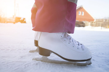 Fototapeta na wymiar Figure skating. Children white skating on ice. Children's winter sports. Outdoor activities in winter.