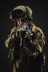 russian special forces soldier with rifle on dark background. army, military and people concept
