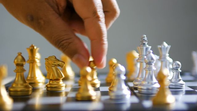 Close up shot hand of man and woman play gold and silver chess metaphor business compettition concept select focus shallow depth of field