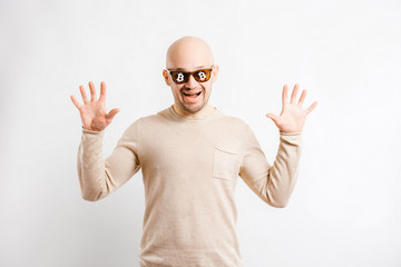 Happy bald businessman with cryptocurrency bitcoin signs on sunglasses. Excited unusual man financial forecast. Successful trader expressive face. Funny blockchain miner portrait isolated on white.