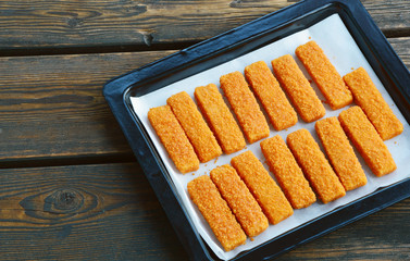 frozen fish sticks in Tray for oven on wooden background