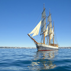 Beautiful sailing ship in the blue sea under sail. Yachting. Sailing
