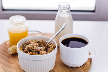 healthy breakfast fresh cereal, milk bottle, coffee cup and honey jar