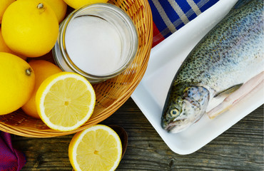 Fish,lemon and salt in the basket on wooden background