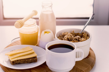 healthy foods for breakfast, milk,honey, cereal, coffee, hard boiled egg , coffee , sandwich with cheese sunny warm toned