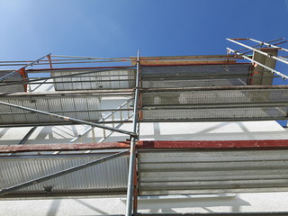 Baustelle Gebäude Gerüst  blauer Himmel Sonnenschein