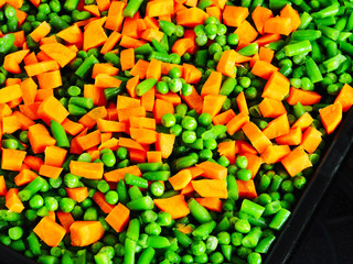 Sliced vegetables before baking on the Pan for baking. Carrots, green peas, green beans. The concept of a healthy diet.