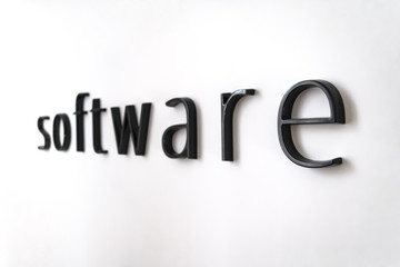 Software word on white painted wall with blurred background