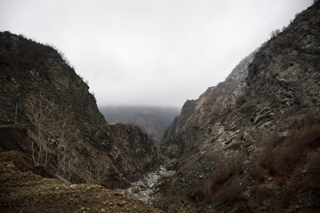 Panorama of the foggy winter landscape in the mountains with snow and rocks, Azerbaijan, Lahic, Big Caucasus