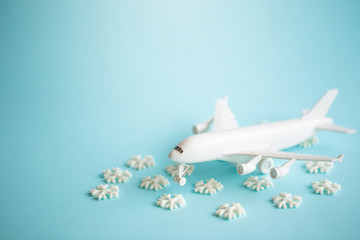 Plastic toy airplane and white snowflakes on Blue sky Background.