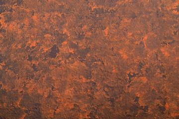 Abstract textured background of putty, painted in rusty-brown color