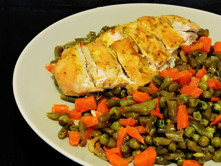 Chicken breast baked with vegetables on a plate. Green peas, carrots, green beans.concept of a healthy diet and fitness lifestyle.
