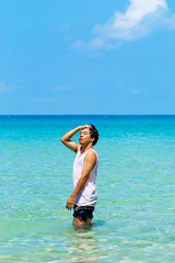 The man is fun and enjoy swimmimg or playing in the clear sea and blue sky background inthe sunny day ,Thailand.