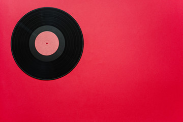 Top view of vintage vinyl record on the red background
