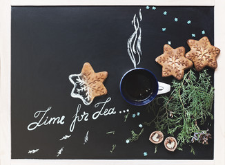 Top view of cup of tea with cookies and nuts on the chalkboard