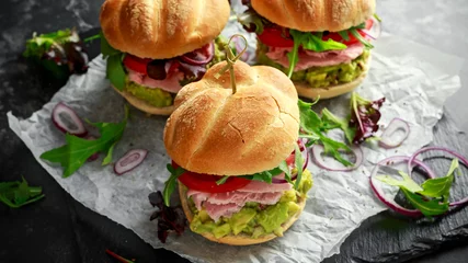 Fototapeten Fresh home sandwich with avocado guacamole, tomatoes, arugula, red onion and ham. © grinchh